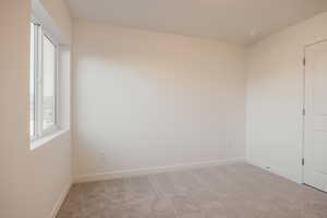 Carpeted empty room featuring baseboards