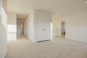 Unfurnished bedroom with light colored carpet, recessed lighting, and a closet