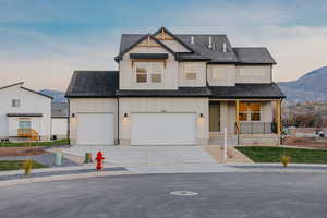 View of front of house with covered porch, board and batten siding, a mountain view, driveway, and a shingled roof