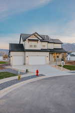 Modern farmhouse with board and batten siding, a mountain view, a porch, and a shingled roof