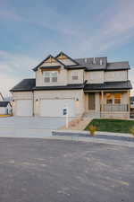 Modern farmhouse with covered porch, board and batten siding, driveway, and an attached garage