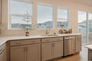 Kitchen featuring dishwasher, healthy amount of natural light, tasteful backsplash, and light wood finished floors