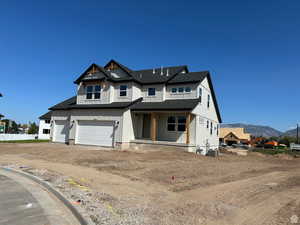 Modern inspired farmhouse featuring a shingled roof, driveway, a porch, a garage, and a mountain view