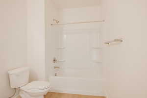 Full bathroom with light wood-style floors and shower / tub combination