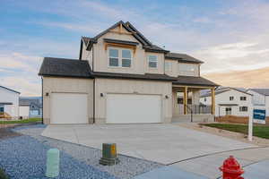 View of front of property with board and batten siding, roof with shingles, and an attached garage