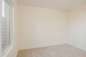 Unfurnished room with light colored carpet and baseboards