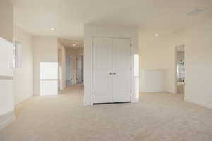 Spare room featuring light colored carpet and recessed lighting