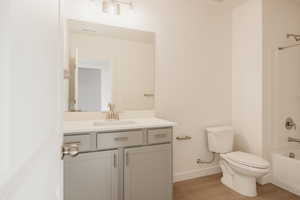 Bathroom with vanity, shower / tub combination, and light wood-style flooring