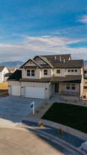 Modern farmhouse style home featuring covered porch, driveway, board and batten siding, and a mountain view