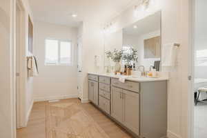Full bath featuring double vanity, light wood-style floors, recessed lighting, and connected bathroom