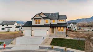Modern inspired farmhouse with covered porch, concrete driveway, board and batten siding, roof with shingles, and a mountain view