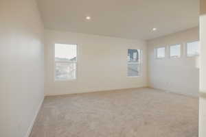 Unfurnished room featuring light carpet, plenty of natural light, and recessed lighting