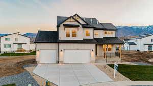 Modern farmhouse style home with a mountain view, board and batten siding, a shingled roof, covered porch, and concrete driveway