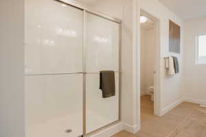 Full bath featuring a shower stall and light wood finished floors