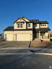 View of front of home featuring concrete driveway, covered porch, roof with shingles, and a garage