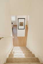 Stairs featuring wood finished floors