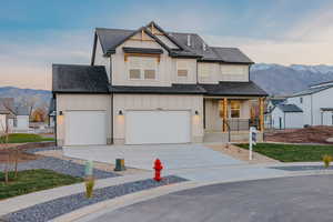 Modern inspired farmhouse with a mountain view, board and batten siding, a porch, and a shingled roof