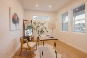 Office with light wood finished floors and recessed lighting