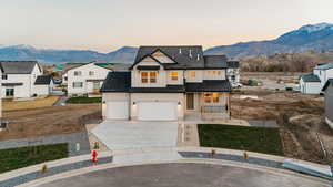 Modern farmhouse style home featuring a mountain view, a porch, roof with shingles, and concrete driveway