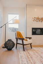 Living area featuring a glass covered fireplace and light wood-style floors