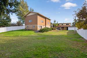 Rear view of house featuring a fenced backyard