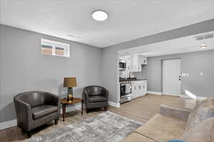 Living room featuring light wood-type flooring and a textured ceiling