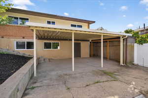 Back of property featuring a carport and a patio area