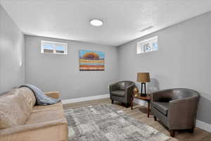 Living area with wood finished floors and a textured ceiling