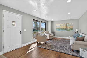 Living area with wood finished floors, recessed lighting, and a textured ceiling