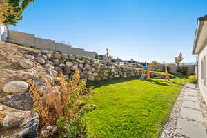 Fenced backyard featuring a playground