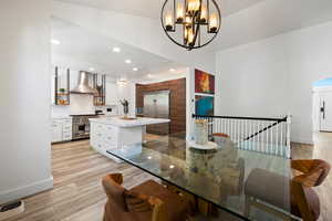 Dining area featuring light wood-type flooring, recessed lighting, and a chandelier
