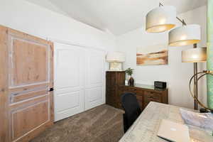 Home office featuring carpet and vaulted ceiling
