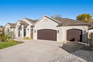 View of front of property featuring stucco siding, concrete driveway, and a garage