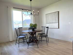 Dining space featuring light wood-type flooring, a chandelier, and a water view