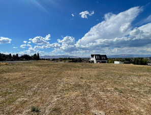 View of grassy yard with a mountain view and a view of rural / pastoral area