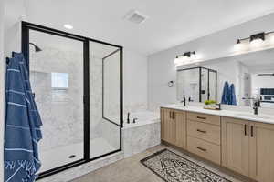 Full bath with a marble finish shower, double vanity, and a bath