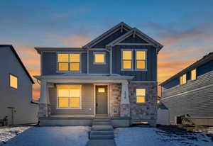 View of front of property with stone siding, board and batten siding, and a porch