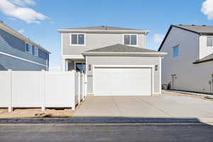 View of front of home with concrete driveway, a shingled roof, and an attached garage