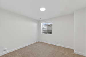 Spare room featuring baseboards and carpet floors