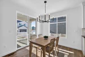 Dining space with a chandelier and dark wood finished floors