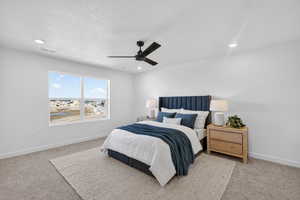 Bedroom with ceiling fan, light colored carpet, recessed lighting, and a textured ceiling