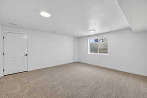 Spare room with light colored carpet and a textured ceiling
