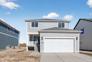 View of front of property featuring concrete driveway, a garage, and roof with shingles
