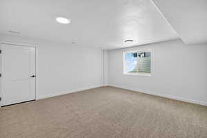 Unfurnished room with light carpet and a textured ceiling