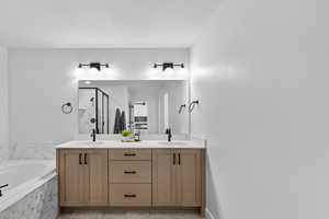 Full bathroom with double vanity, a stall shower, and a bath