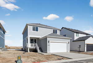 Traditional-style house with concrete driveway, a garage, and roof with shingles