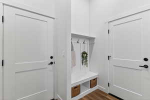 Mudroom with dark wood finished floors and baseboards
