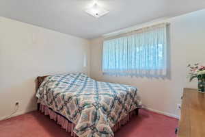 Carpeted bedroom featuring baseboards