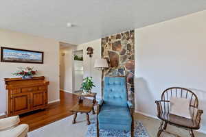 Sitting room featuring a textured ceiling and wood finished floors