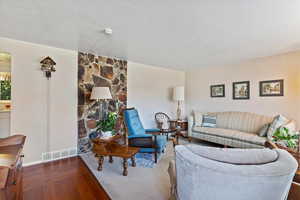Living room featuring a textured ceiling and dark wood finished floors